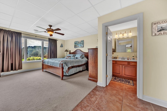 tiled bedroom featuring ceiling fan, sink, a paneled ceiling, and ensuite bathroom