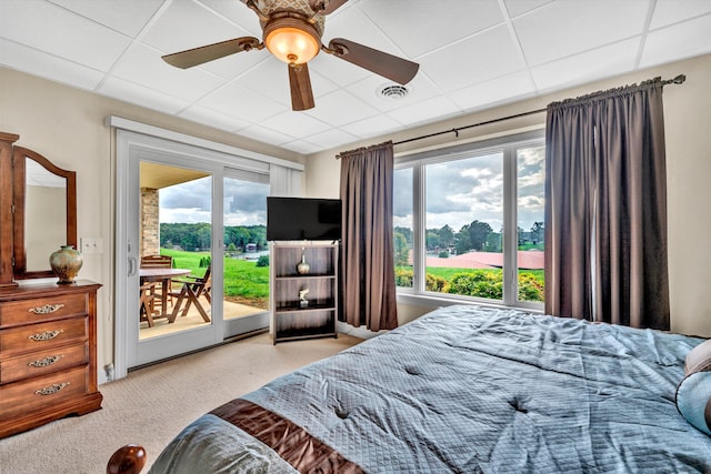 bedroom with a drop ceiling, ceiling fan, access to exterior, and light carpet