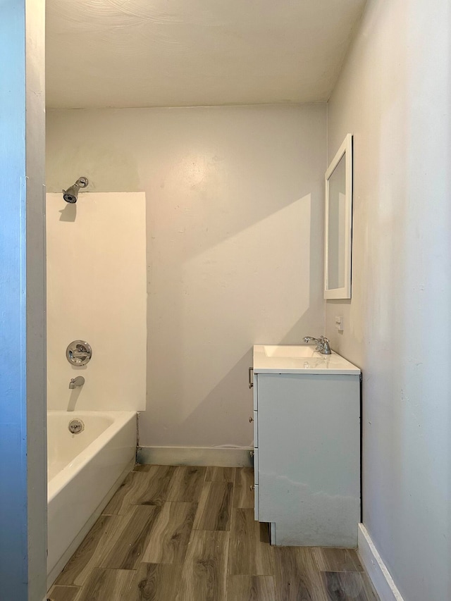 bathroom with shower / tub combination, hardwood / wood-style floors, and vanity