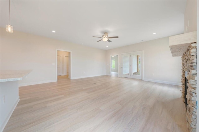 unfurnished living room with light wood-type flooring, ceiling fan, baseboards, and recessed lighting