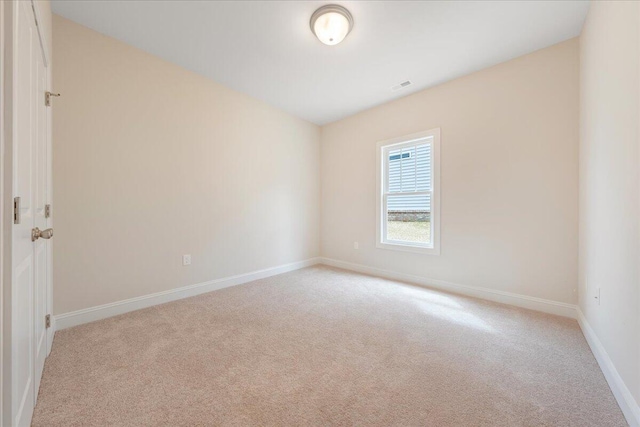 unfurnished room with light carpet, visible vents, and baseboards