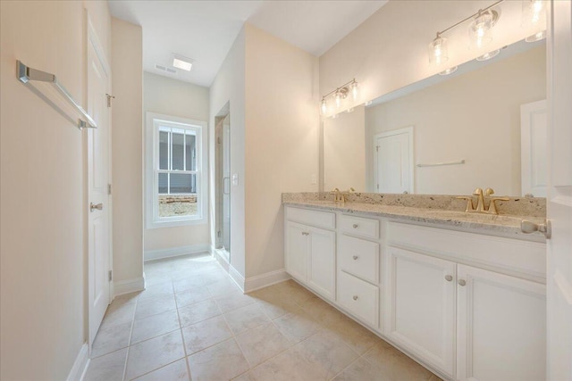 bathroom with baseboards, tile patterned floors, a sink, and a stall shower