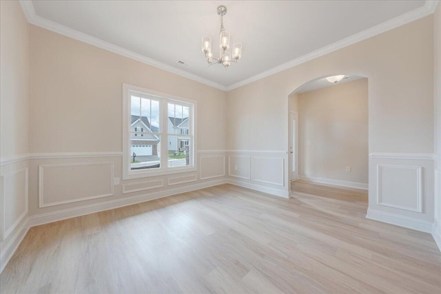 empty room with ornamental molding, light hardwood / wood-style floors, and a notable chandelier