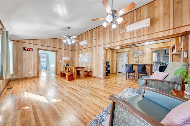 living room featuring high vaulted ceiling, wood-type flooring, wood walls, and ceiling fan