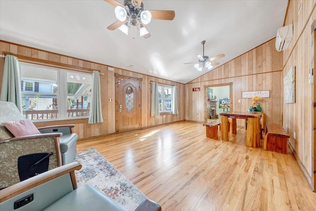 living room with wooden walls, vaulted ceiling, light wood-type flooring, and a wall mounted air conditioner