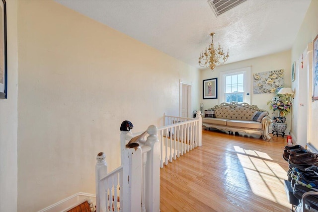 interior space with a notable chandelier, a textured ceiling, and hardwood / wood-style flooring