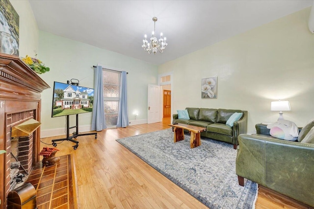 living room featuring a chandelier, a wall unit AC, hardwood / wood-style flooring, and a fireplace