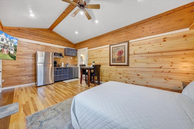 bedroom with wooden walls, stainless steel fridge, lofted ceiling with beams, and light hardwood / wood-style flooring