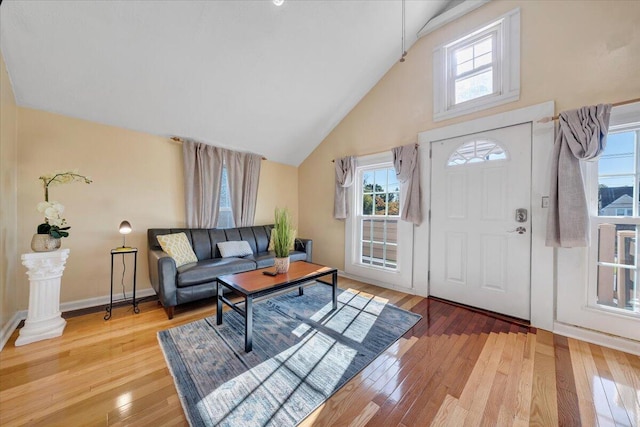 entrance foyer with wood-type flooring, high vaulted ceiling, and a wealth of natural light