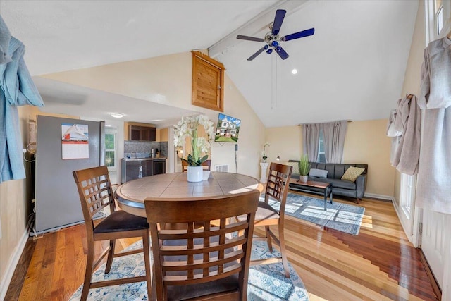 dining room featuring hardwood / wood-style floors, ceiling fan, and high vaulted ceiling