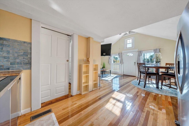 dining area with vaulted ceiling and hardwood / wood-style flooring