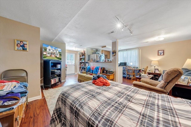 bedroom with a textured ceiling and hardwood / wood-style floors