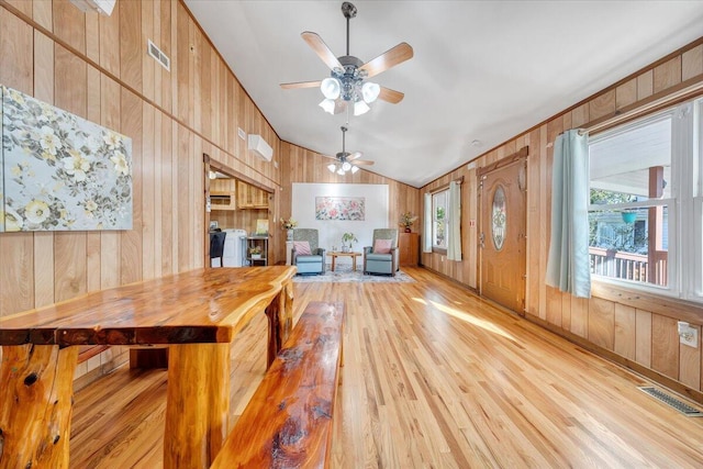 kitchen featuring ceiling fan, wood walls, vaulted ceiling, light hardwood / wood-style floors, and butcher block counters