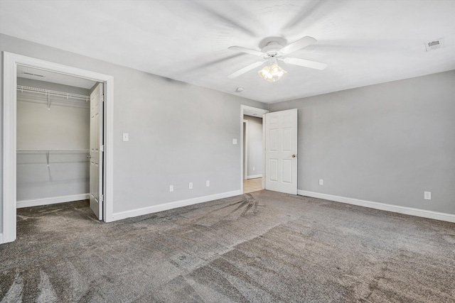 unfurnished bedroom with dark carpet, a closet, and ceiling fan