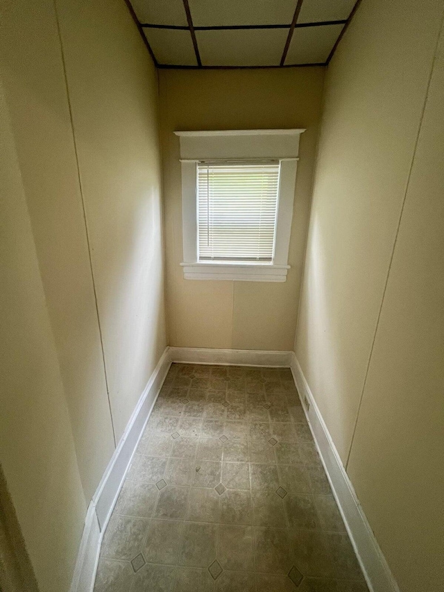 unfurnished room featuring light tile patterned flooring and a drop ceiling