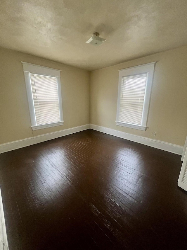 spare room with dark hardwood / wood-style flooring