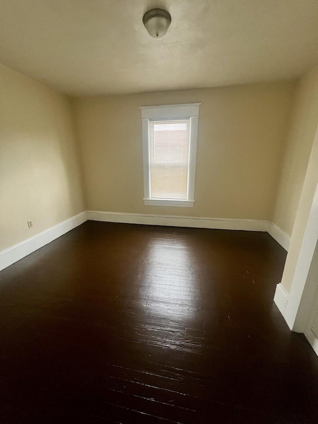 spare room with dark hardwood / wood-style flooring