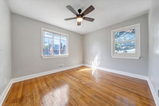 empty room with ceiling fan and hardwood / wood-style flooring