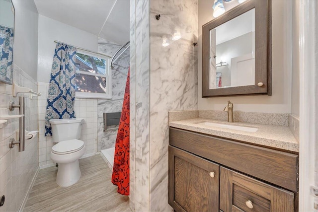 bathroom featuring toilet, a shower with curtain, vanity, and tile walls