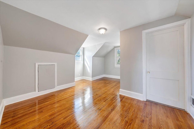 bonus room featuring lofted ceiling and light wood-type flooring