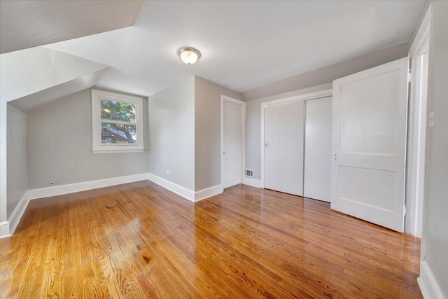 bonus room with lofted ceiling and light hardwood / wood-style flooring