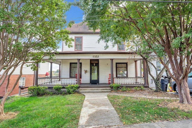 view of front of house with a front yard and a porch