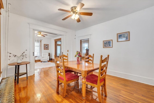 dining area with light hardwood / wood-style floors, a healthy amount of sunlight, and ceiling fan