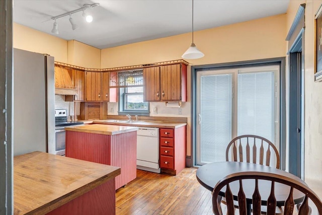 kitchen featuring light wood-type flooring, a kitchen island, butcher block countertops, stainless steel range oven, and white dishwasher