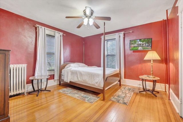 bedroom featuring ceiling fan, hardwood / wood-style flooring, and radiator