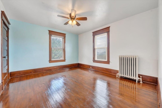 unfurnished room featuring radiator, ceiling fan, and hardwood / wood-style flooring