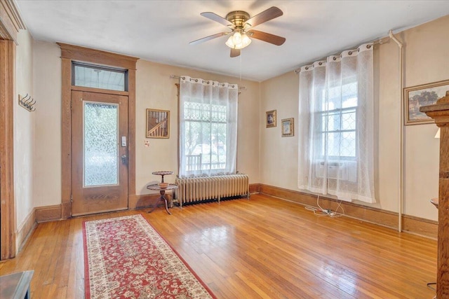 foyer with light hardwood / wood-style floors, radiator heating unit, and plenty of natural light