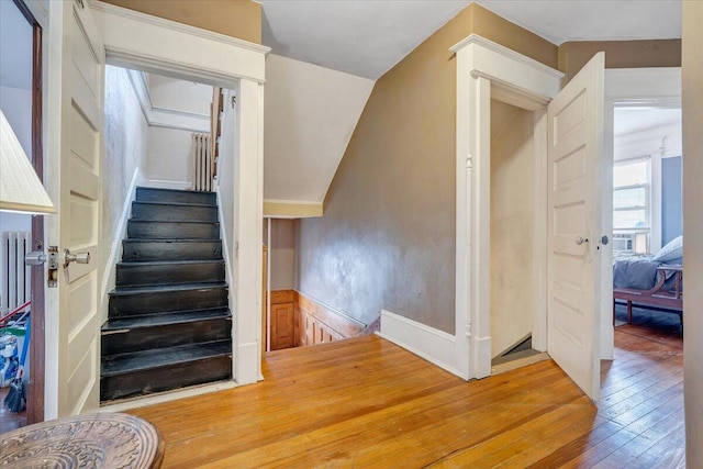 staircase featuring lofted ceiling and hardwood / wood-style flooring