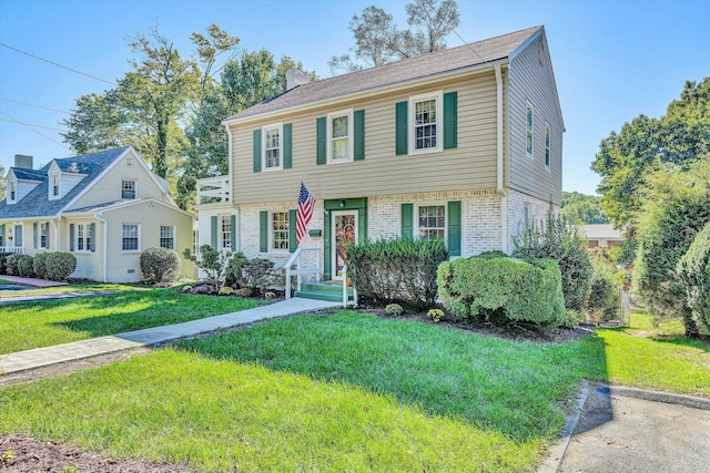 colonial-style house featuring a front lawn