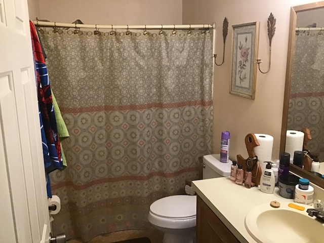 bathroom with walk in shower, vanity, and toilet