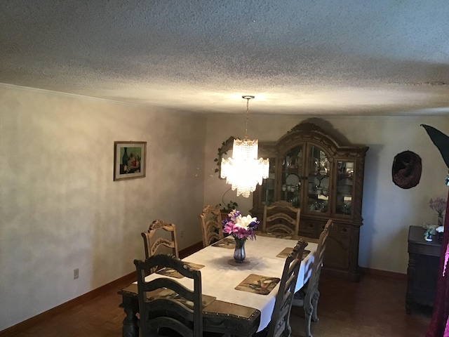 dining room with an inviting chandelier, dark hardwood / wood-style flooring, and a textured ceiling