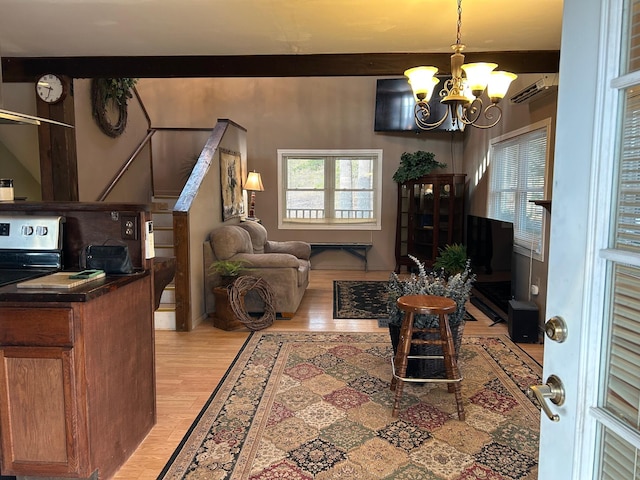 living room featuring an inviting chandelier, beam ceiling, light hardwood / wood-style floors, and a wall mounted AC