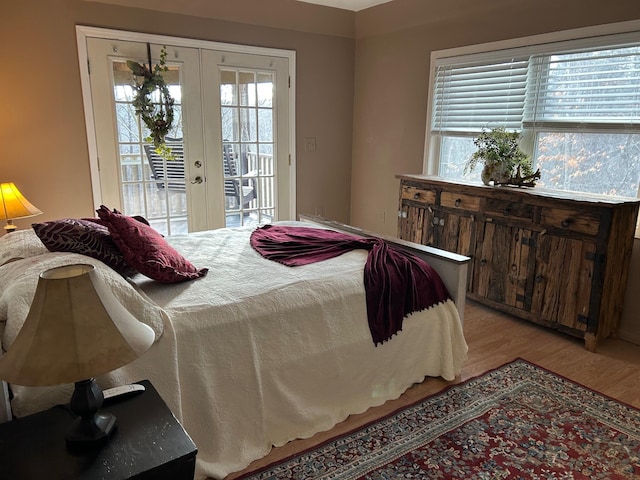 bedroom featuring french doors, access to exterior, multiple windows, and light wood-type flooring