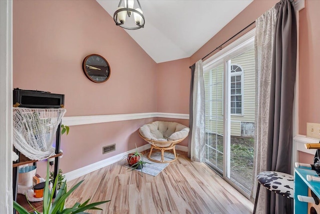 sitting room with vaulted ceiling and light hardwood / wood-style flooring