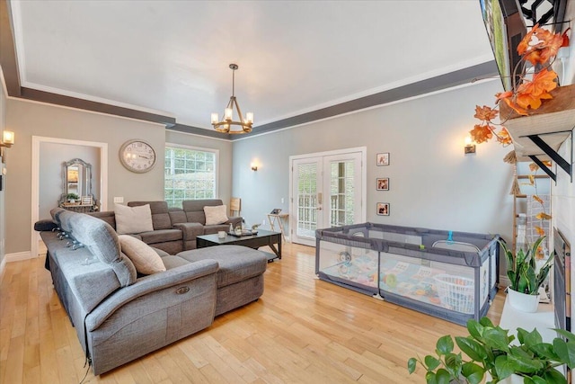 living room featuring crown molding, plenty of natural light, and light wood-type flooring