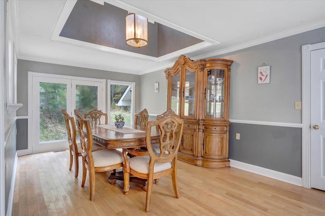 dining room featuring french doors, ornamental molding, and light hardwood / wood-style flooring