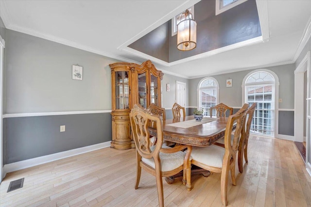 dining room featuring crown molding and light hardwood / wood-style floors