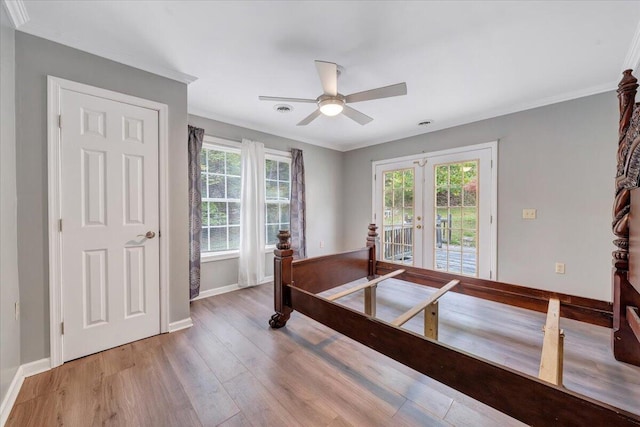 bedroom featuring ceiling fan, hardwood / wood-style floors, access to exterior, ornamental molding, and french doors