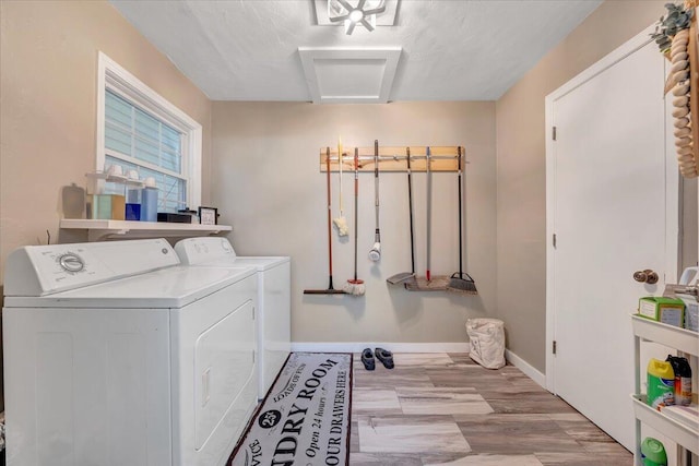 clothes washing area featuring light wood-type flooring and washer and clothes dryer