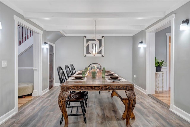 dining space with wood-type flooring and beam ceiling