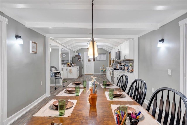 dining area featuring lofted ceiling with beams and hardwood / wood-style floors