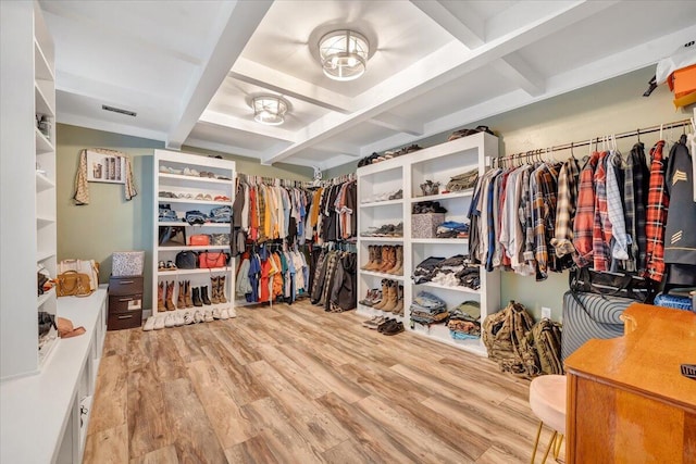 walk in closet with beam ceiling and hardwood / wood-style flooring