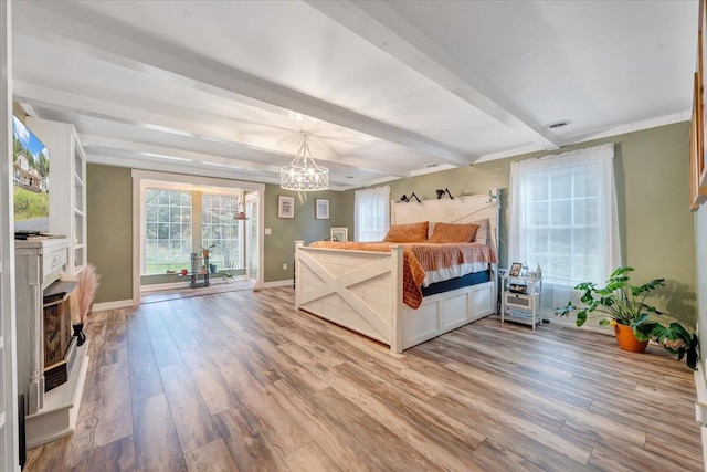 bedroom with hardwood / wood-style flooring, beam ceiling, and a chandelier