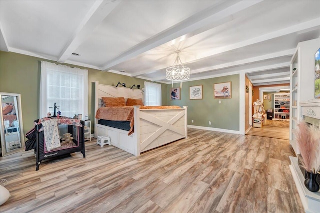 bedroom with beamed ceiling, a chandelier, and light wood-type flooring