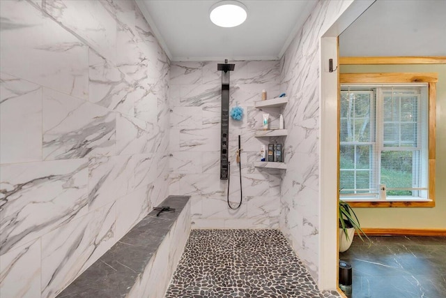 bathroom with ornamental molding and a tile shower