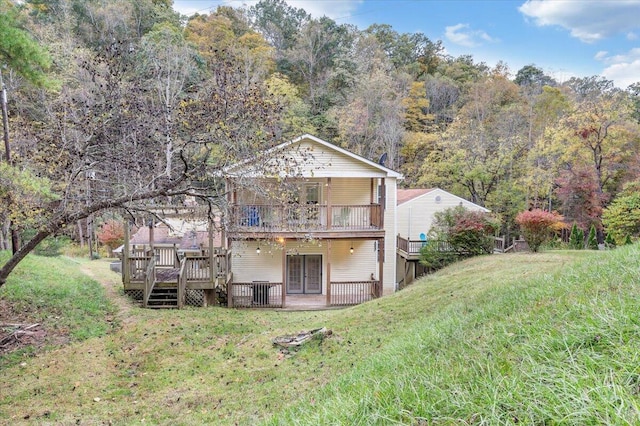 back of property featuring a wooden deck and a lawn